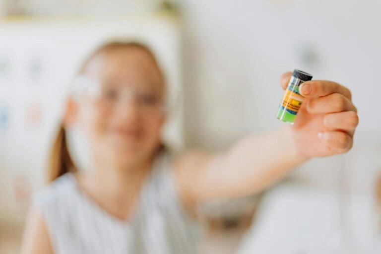A smiling girl holds a colorful vial, exploring a science experiment in a playful setting.